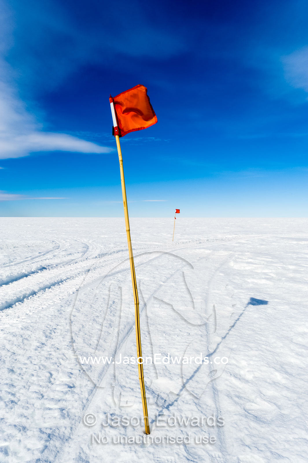 A red flag highlights a safe route across the sea ice. Haskell Strait, Cape Armitage, McMurdo Sound, Ross Island, Antarctica.