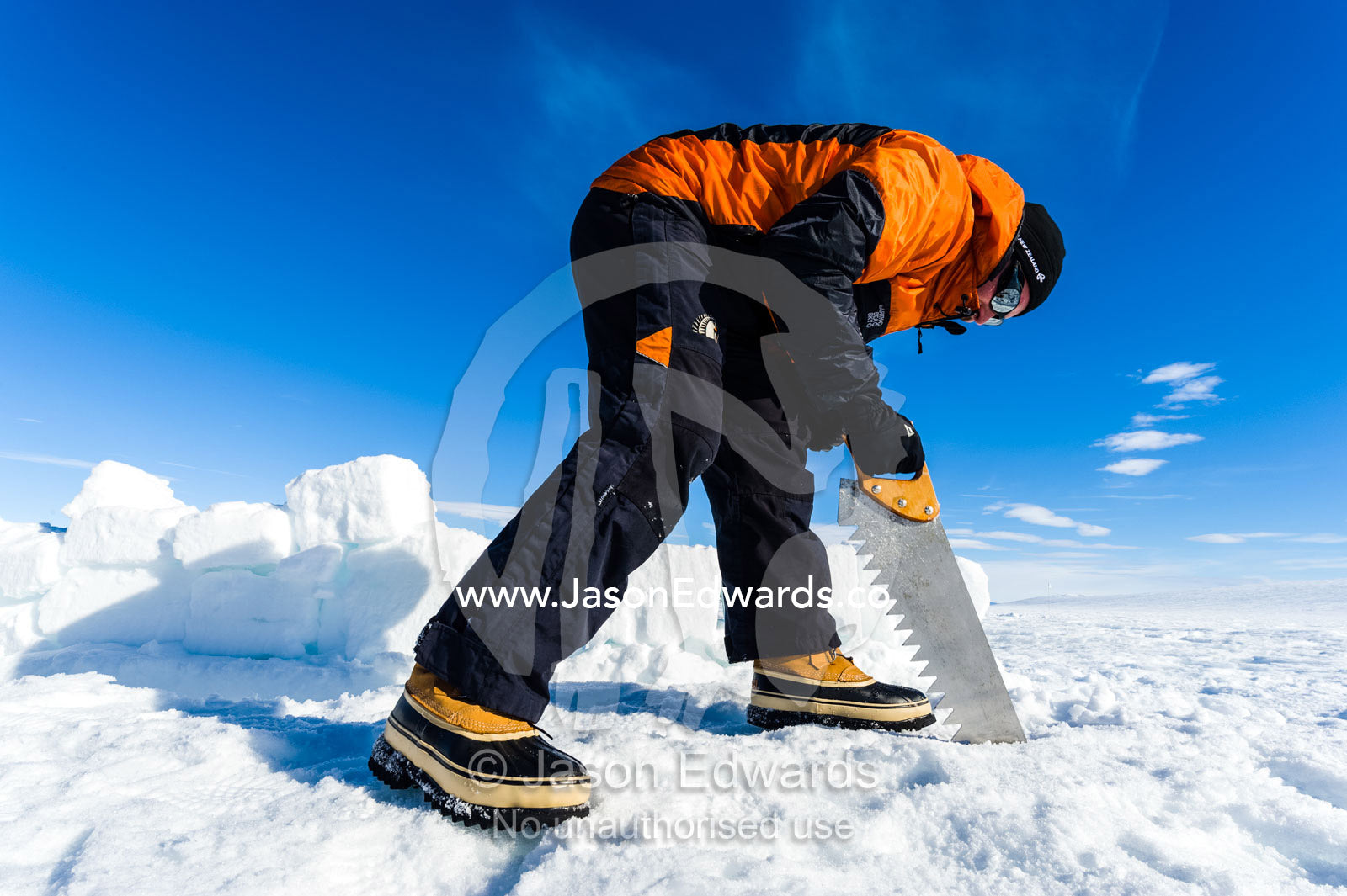 Antarctic base staff cutting ice bricks to make a kitchen wall on the sea ice during a survival course. Windless Bight, Ross Ice Shelf, Ross Island, Antarctica.