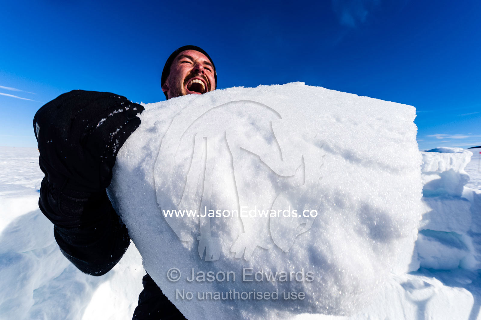 Antarctic base staff lifting ice bricks to make a kitchen wall on the sea ice during a survival course. Windless Bight, Ross Ice Shelf, Ross Island, Antarctica.