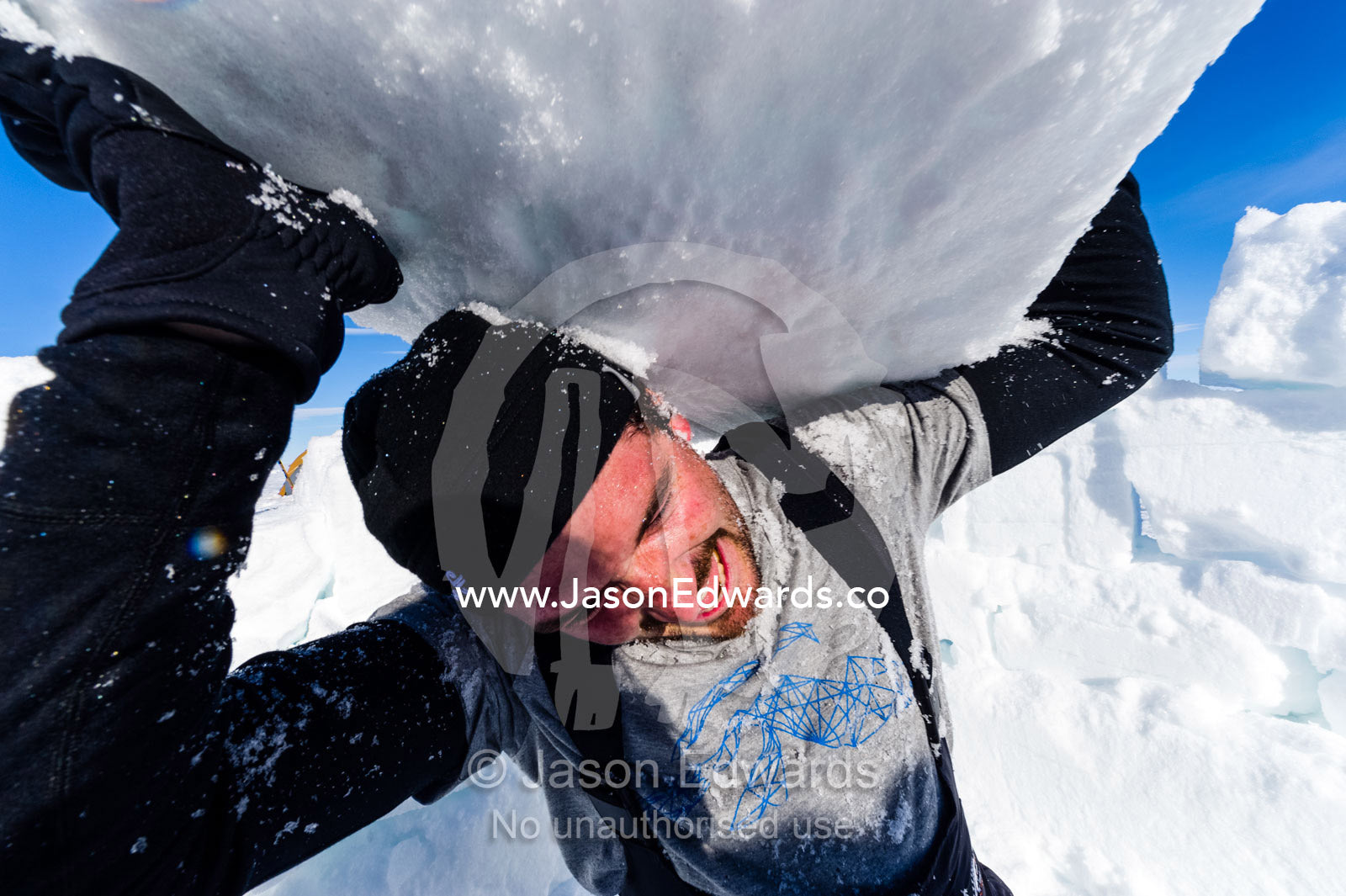 Antarctic base staff lifting ice bricks to make a kitchen wall on the sea ice during a survival course. Windless Bight, Ross Ice Shelf, Ross Island, Antarctica.