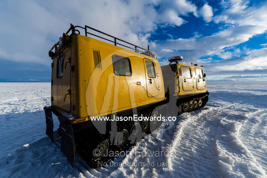 A Hagglund ice vehicle travels over a bridge on sea ice during the Antarctic summer. Windless Bight, Ross Ice Shelf, Ross Island, Antarctica.