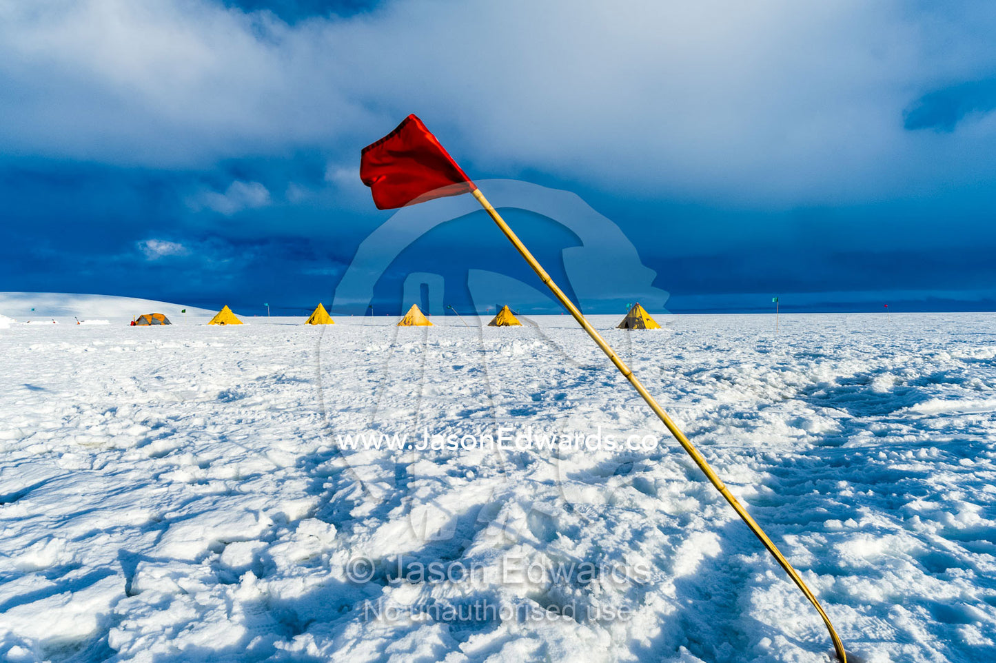 A red flag bending in the wind the amount of bend indicates the wind speed. Windless Bight, Ross Ice Shelf, Ross Island, Antarctica.