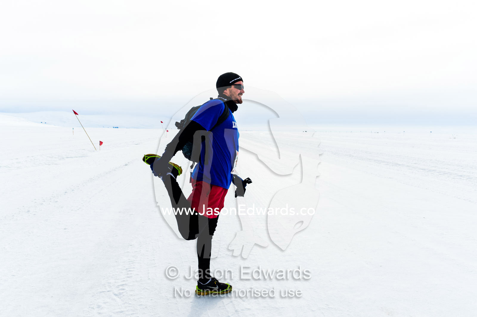 A runner warms up and stretches before the Antarctic marathon. Ross Ice Shelf, Ross Island, Antarctica.