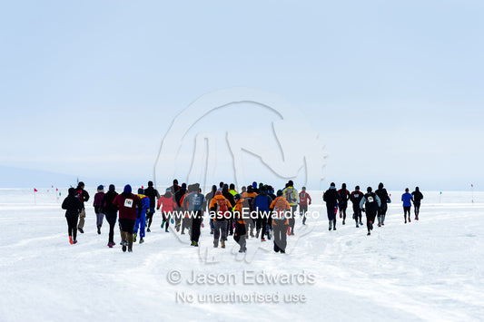 Runners from the Antarctic bases cross the sea ice during the Antarctic marathon. Ross Ice Shelf, Ross Island, Antarctica.
