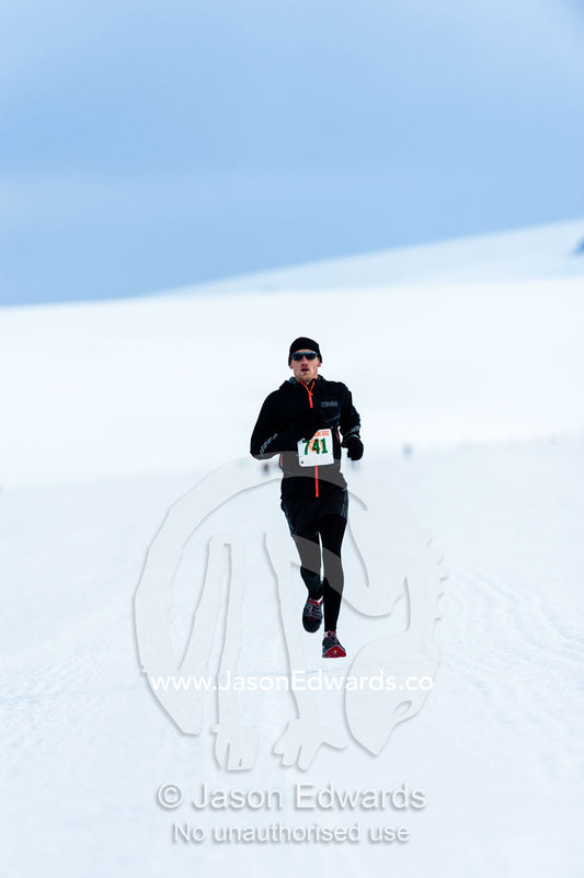 A solitary runner crosses the sea ice during the Antarctic marathon. Ross Ice Shelf, Ross Island, Antarctica.