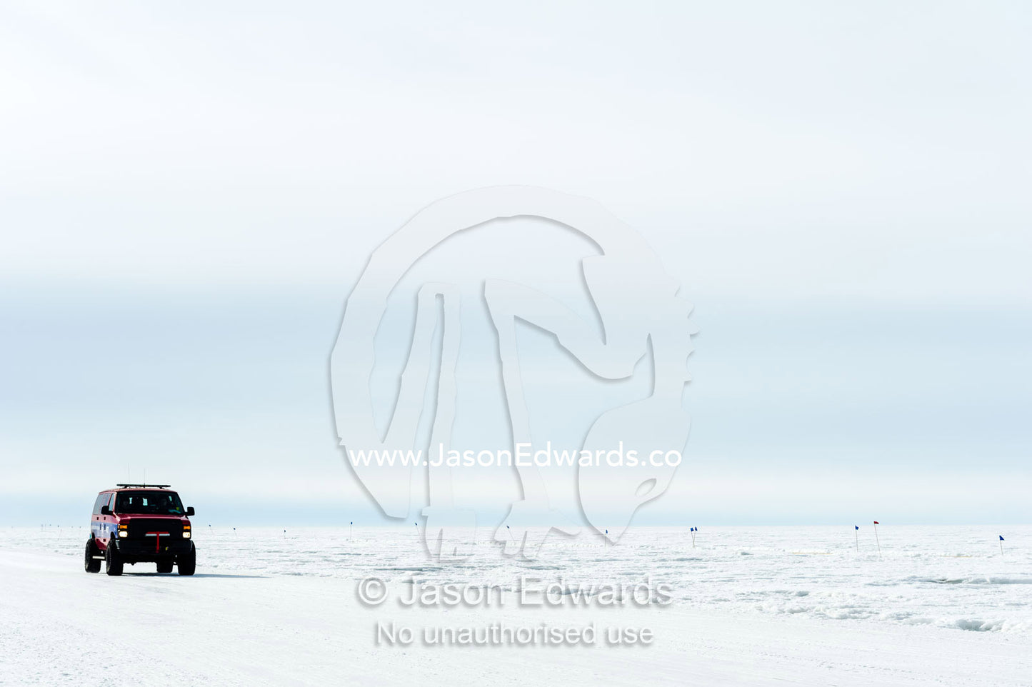 A support vehicle crosses the sea ice to monitor runners in the Antarctic marathon. Ross Ice Shelf, Ross Island, Antarctica.