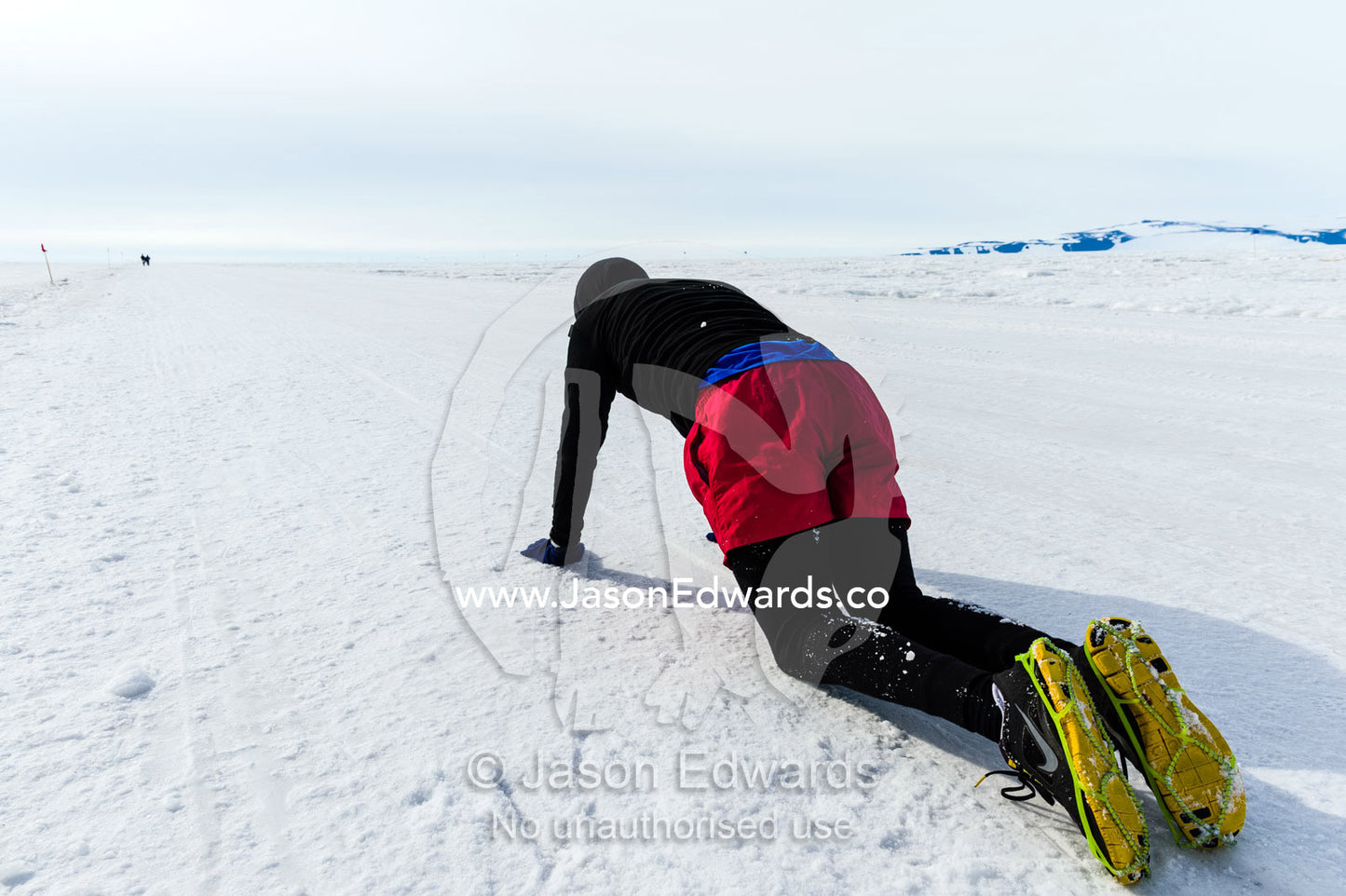A runner collapses on the sea ice during the Antarctic marathon. Ross Ice Shelf, Ross Island, Antarctica.