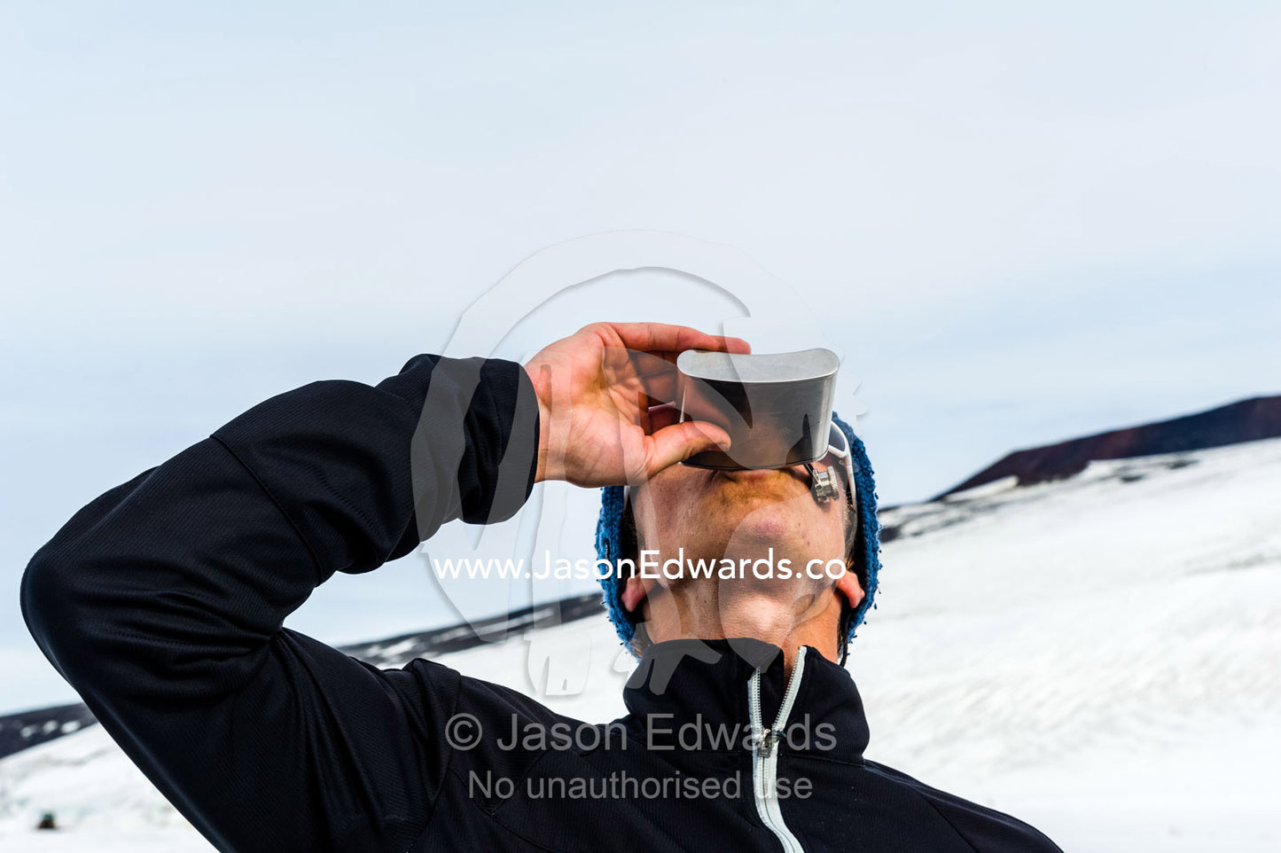 The winner of the Antarctic marathon celebrates with a drink from a hip flask. Ross Ice Shelf, Ross Island, Antarctica.