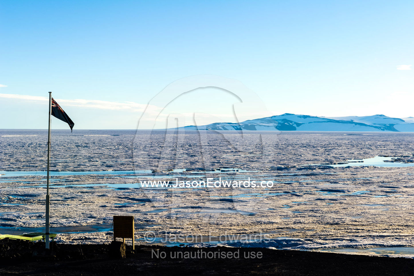 Ocean pools expand where the Antarctic sea ice is melting in summer near a research base. Scott Base, Pram Point, Hut Point Peninsula, Ross Island, Antarctica.