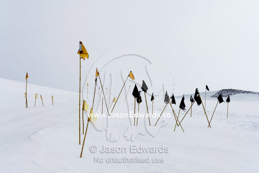 Warning flags mark dangerous crevasse on a mountainside. Castle Rock Road, Hut Point Peninsula, Ross Island, Antarctica.