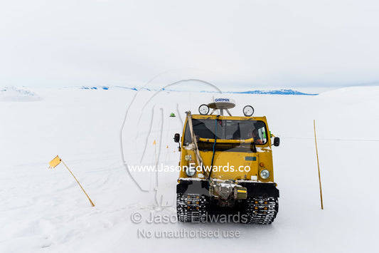 A Hagglund ice vehicle travels between crevasse on a mountain during the Antarctic summer. Castle Rock Road, Hut Point Peninsula, Ross Island, Antarctica.