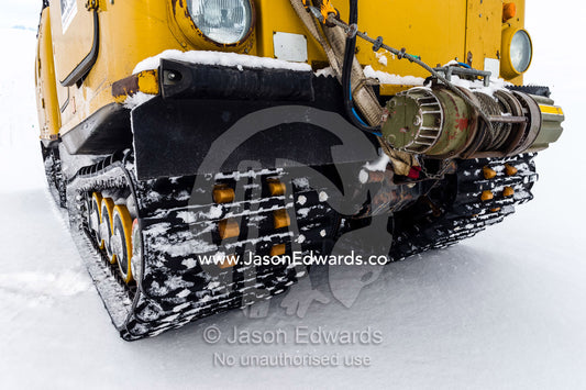 A Hagglund ice vehicle travels between crevasse on a mountain during the Antarctic summer. Turtle Rock, Erebus Bay, McMurdo Sound, Ross Island, Antarctica.
