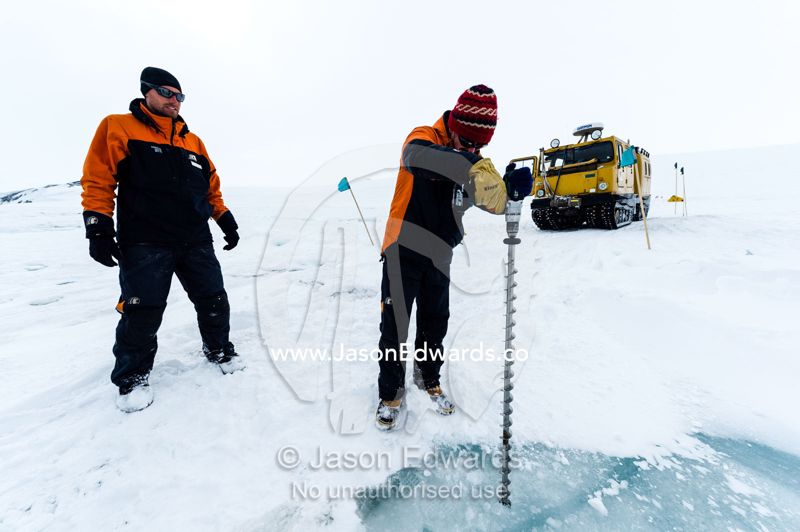 Testing the depth of sea ice for a Hagglund ice vehicle safety during the Antarctic summer. Turtle Rock, Erebus Bay, McMurdo Sound, Ross Island, Antarctica.