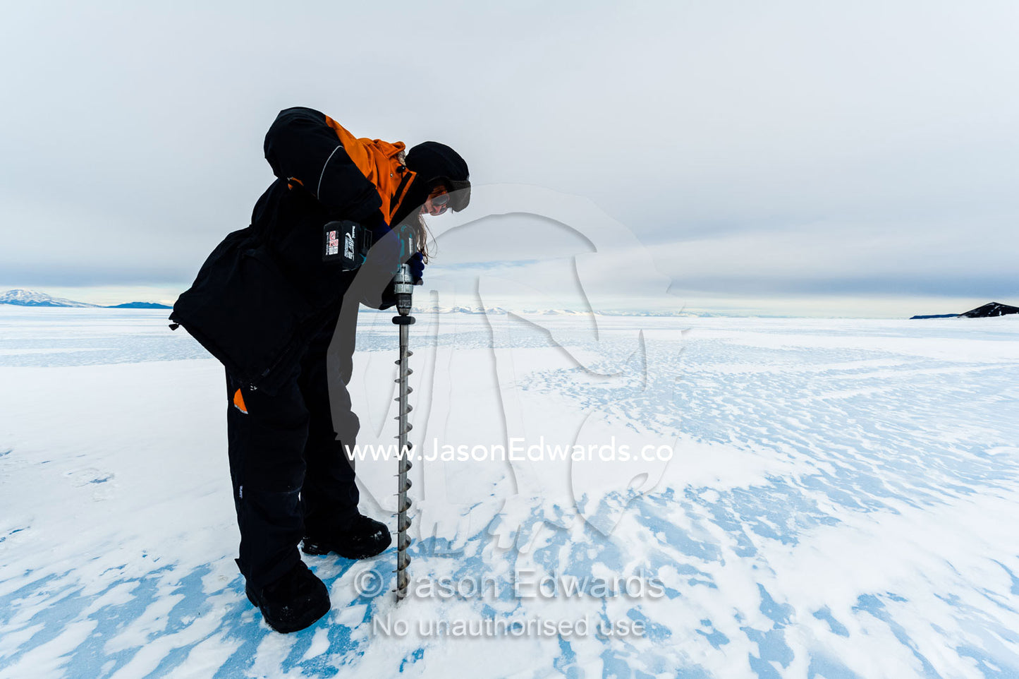 Testing the depth of sea ice for a Hagglund ice vehicle safety during the Antarctic summer. Turtle Rock, Erebus Bay, McMurdo Sound, Ross Island, Antarctica.