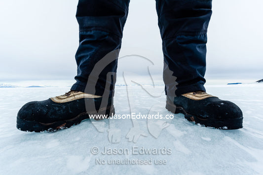 Extreme cold weather boots enable researcher to work on the sea ice. Turtle Rock, Erebus Bay, McMurdo Sound, Ross Island, Antarctica.