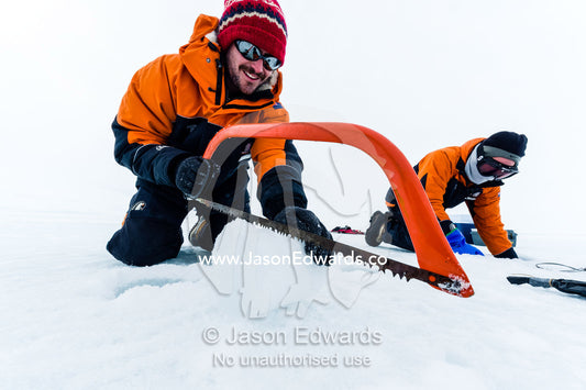 Researchers drill core samples from the sea ice and cut them with a saw to collect extremophiles from beneath the ice to study. Turtle Rock, Erebus Bay, McMurdo Sound, Ross Island, Antarctica.