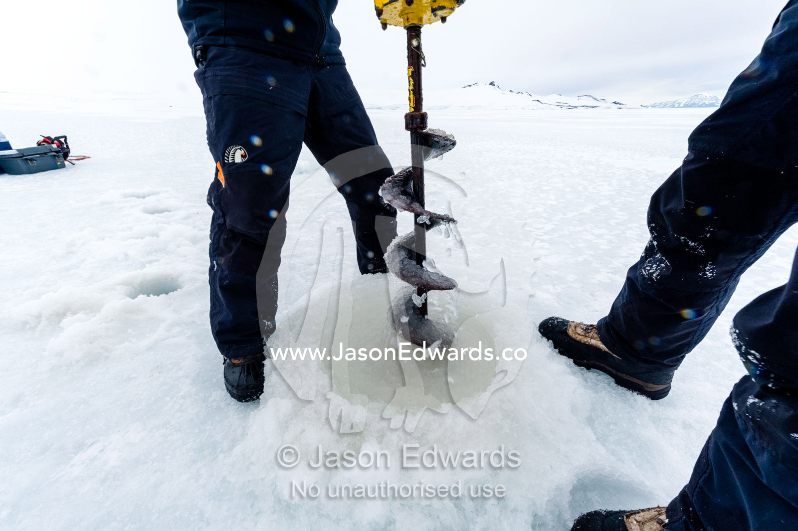 Researchers drill core samples from the sea ice to collect extremophiles from the ocean beneath the ice to study. Turtle Rock, Erebus Bay, McMurdo Sound, Ross Island, Antarctica.