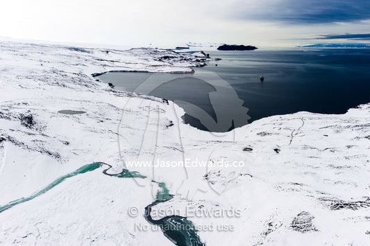 Melt pools forming along the shoreline of a small bay in Antarctica. Wohlschlag Bay, Endeavour Piedmont, Mount Erebus, Ross Island, Antarctica.