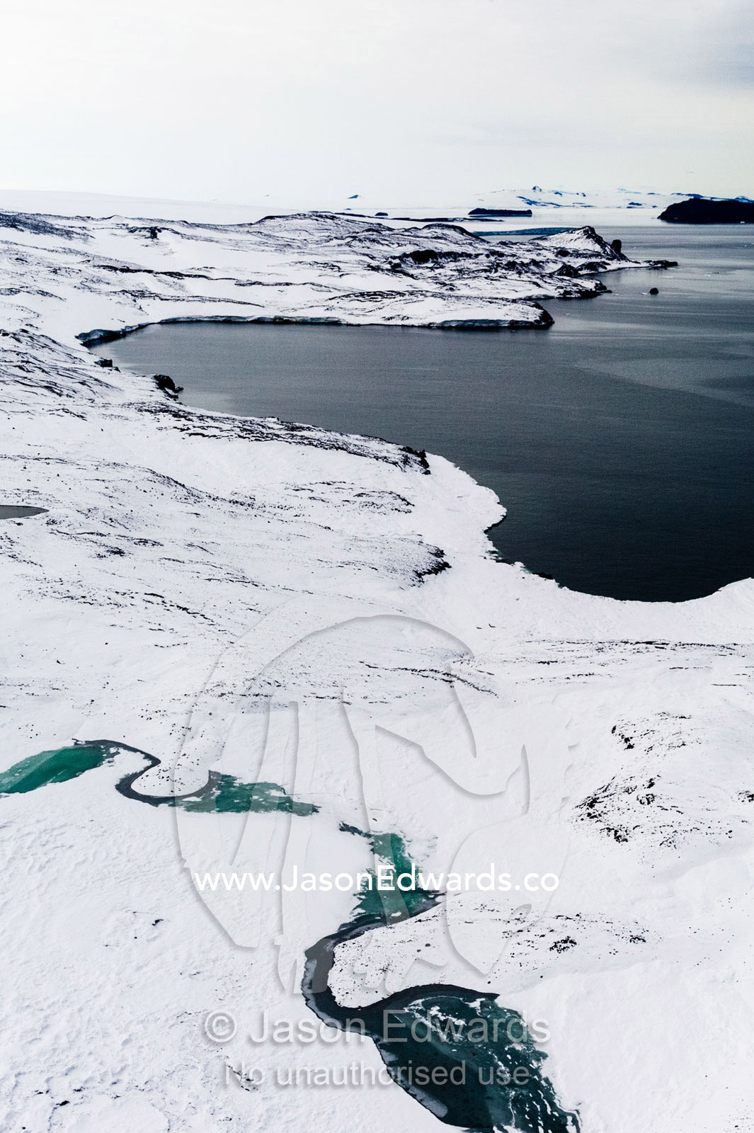 Melt pools forming along the shoreline of a small bay in Antarctica. North Bay, Cape Evans, Ross Island, Antarctica.