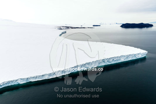Towering ocean ice cliffs and crevasse fields of a glacier flowing off the slopes of Mount Erebus an active volcano. North Bay, Cape Evans, Ross Island, Antarctica.