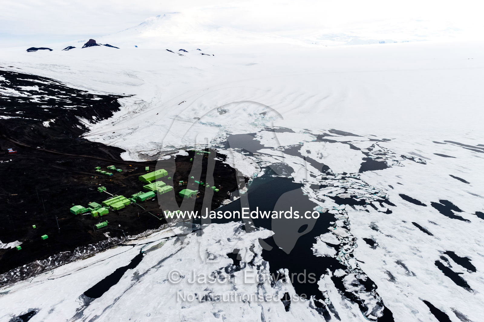 Melt pools form in the sea ice along the shore near Scott Base. Scott Base, Pram Point, Hut Point Peninsula, Ross Island, Antarctica.