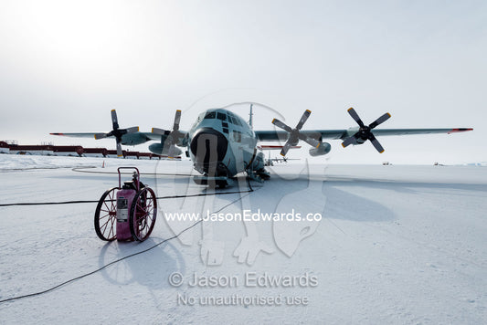 Refueling a US Air force Hercules resting on skis on a sea ice tarmac. Royal Society Range, Pegasus Field, McMurdo Ice Shelf, Ross Island, McMurdo Sound, Antarctica.