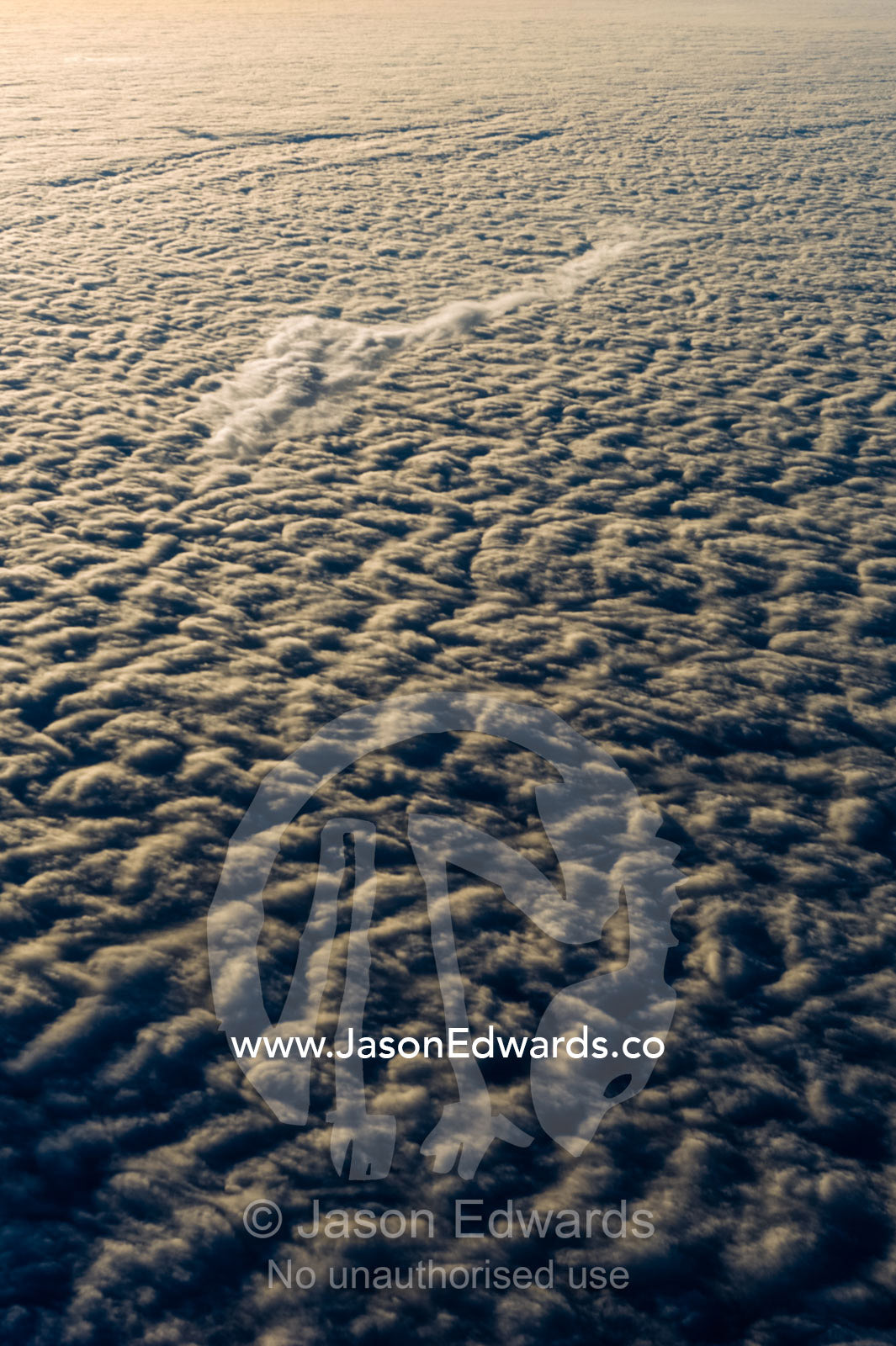 Sunset touches the surface of a cloud bank over the Southern Ocean. Southern Ocean, between New Zealand and Antarctica.