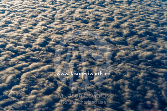 Sunset touches the surface of a cloud bank over the Southern Ocean. Southern Ocean, between New Zealand and Antarctica.