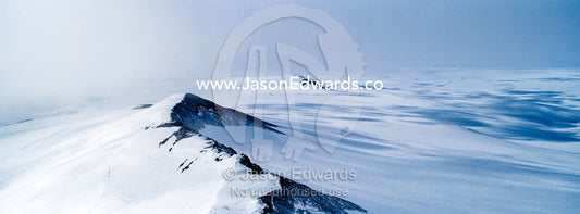 A vast snow-covered mountain ridge during a break in an Antarctic storm. Breached Cone, Castle Rock, Hut Point Peninsula, Ross Island, Antarctica.