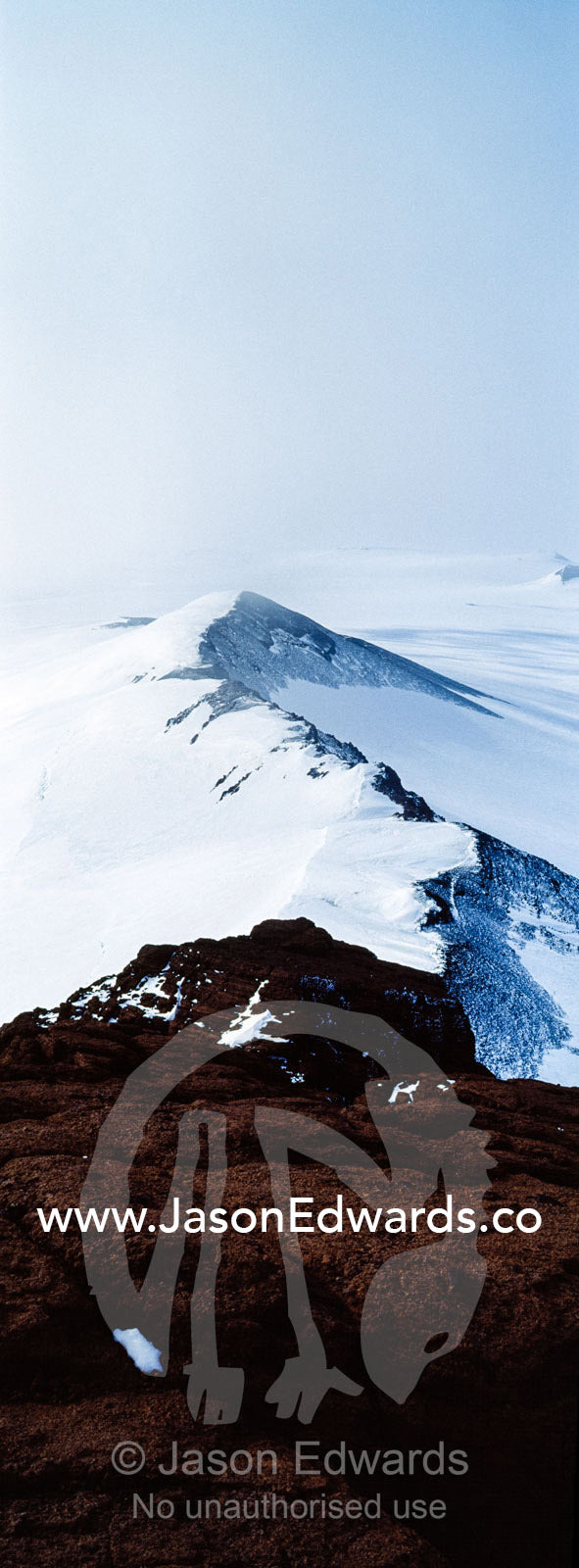 A jagged snow-covered mountain ridge during a break in an Antarctic storm. Breached Cone, Castle Rock, Hut Point Peninsula, Ross Island, Antarctica.
