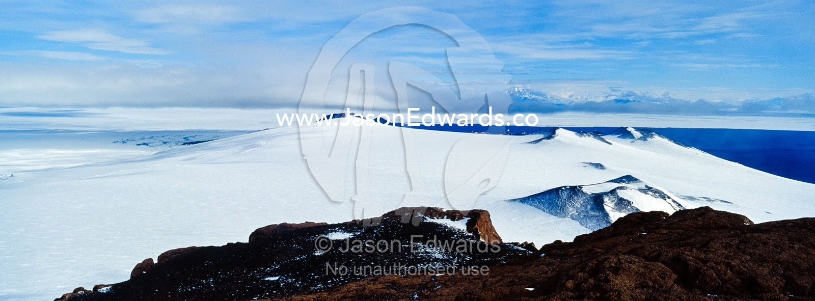 A snow and ice covered mountain plateau overlooking the Ross Sea. Castle Rock, Hut Point Peninsula, Ross Island, Antarctica.