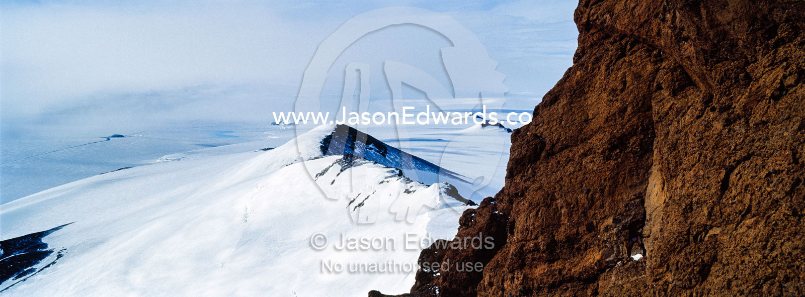 A jagged snow-covered mountain ridge during a break in an Antarctic storm. Breached Cone, Castle Rock, Hut Point Peninsula, Ross Island, Antarctica.