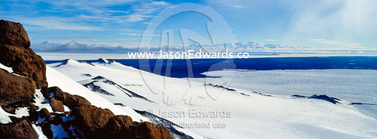 A snow and ice covered mountain plateau overlooking the Ross Sea. Royal Society Range, Castle Rock, Hut Point Peninsula, Ross Island, Antarctica.
