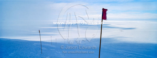 A red flag highlights a safe route across the sea ice. Castle Rock Road, Hut Point Peninsula, Ross Island, Antarctica.