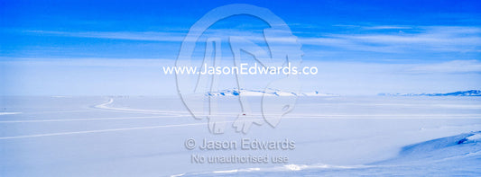 The vast barren expanse of the Ross Ice Shelf fills the horizon. Ross Ice Shelf, Ross Island, Antarctica.