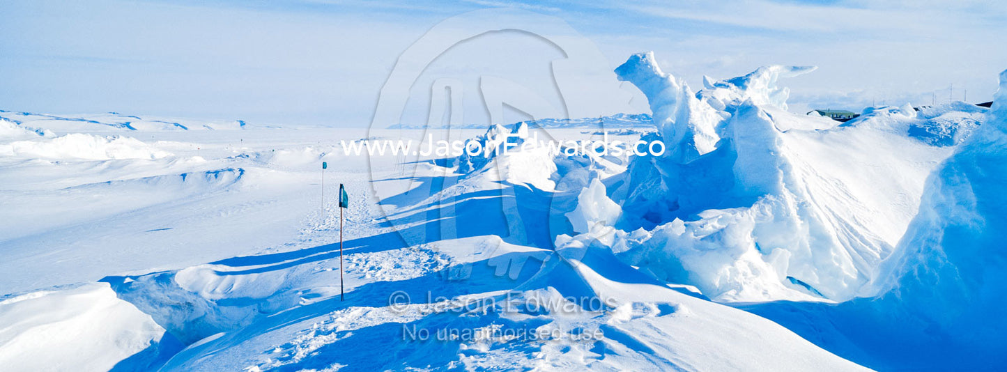 Enormous blocks of ice are pushed skyward along pressure ridges as the sea ice thins and forms melt pools. Pram Point, McMurdo Sound, Ross Island, Antarctica.