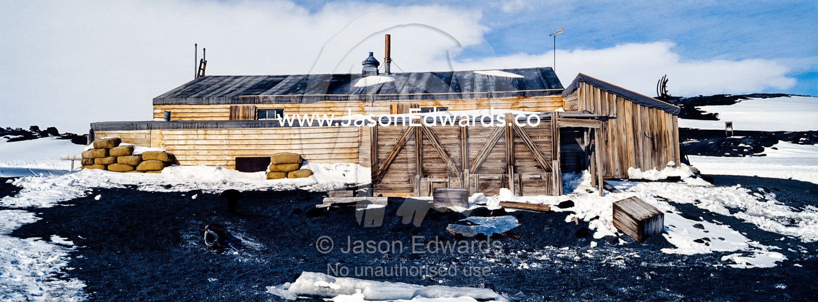 The weathered walls and window shutters of the Antarctic explorer Robert Falcon Scott's hut surrounded by snow. Scott's Hut, Cape Evans, Ross Island, Antarctica.
