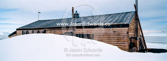 The weathered walls and window shutters of the Antarctic explorer Robert Falcon Scott's hut surrounded by snow. Scott's Hut, Cape Evans, Ross Island, Antarctica.