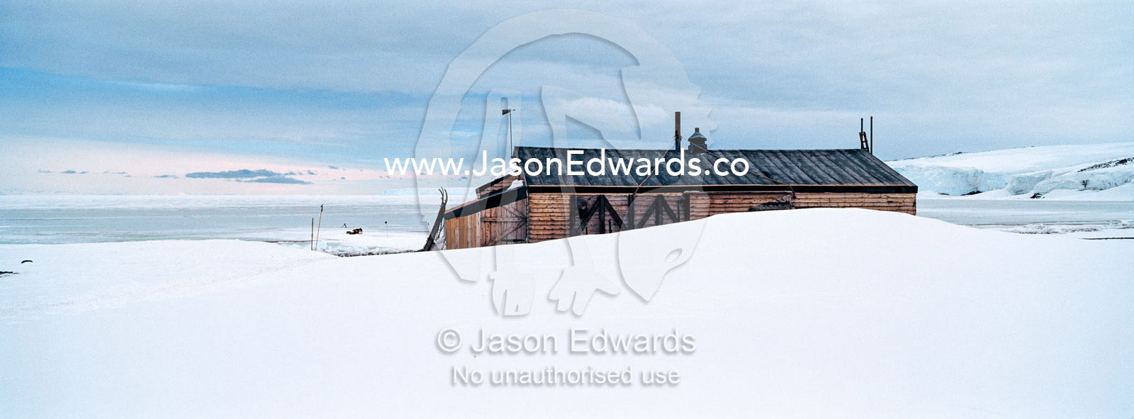 The weathered walls and window shutters of the Antarctic explorer Robert Falcon Scott's hut surrounded by snow. Scott's Hut, Cape Evans, Ross Island, Antarctica.