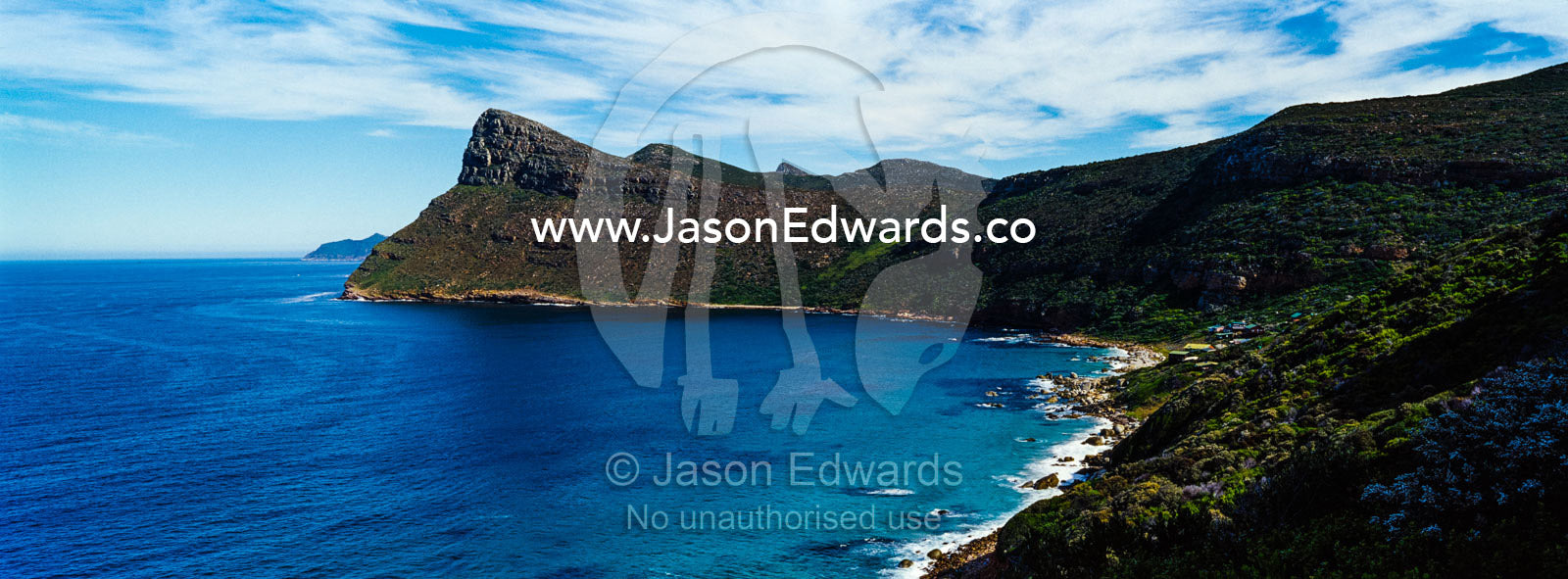Sheer cliffs and mountain peaks overlooking a blue sea along the Cape of Good Hope. Cape of Good Hope, Cape Point, Table Mountain National Park, Cape Peninsula, South Africa.