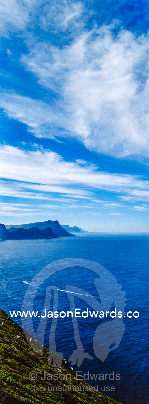 Sheer cliffs and mountain peaks overlooking a blue sea along the Cape of Good Hope. Cape of Good Hope, Cape Point, Table Mountain National Park, Cape Peninsula, South Africa.