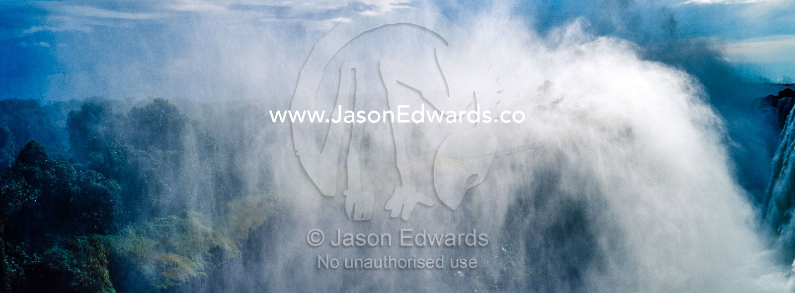 A mist plume rises from the Victoria Falls cataract. Zambezi River, Victoria Falls, Mosi-oa-Tunya National Park, Zambia.