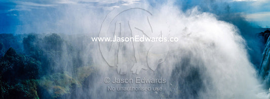 A mist plume rises from the Victoria Falls cataract. Zambezi River, Victoria Falls, Mosi-oa-Tunya National Park, Zambia.