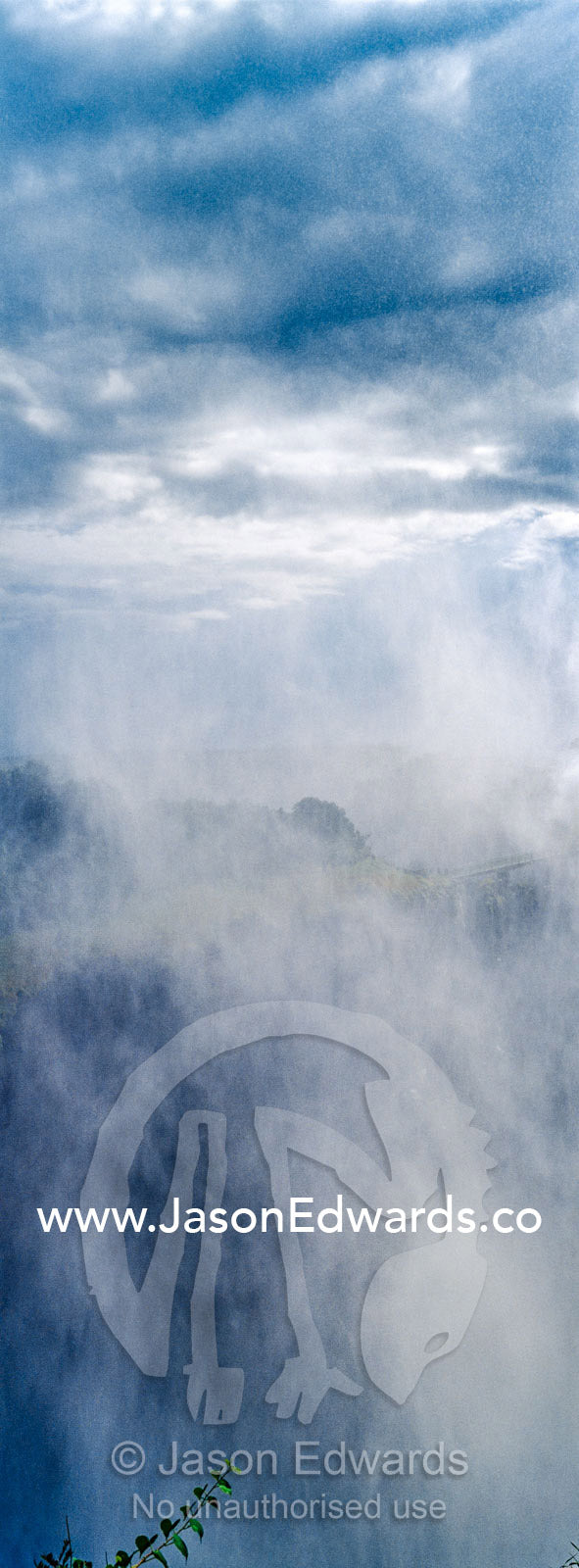 A mist plume rises from the Victoria Falls cataract. Zambezi River, Victoria Falls, Mosi-oa-Tunya National Park, Zambia.