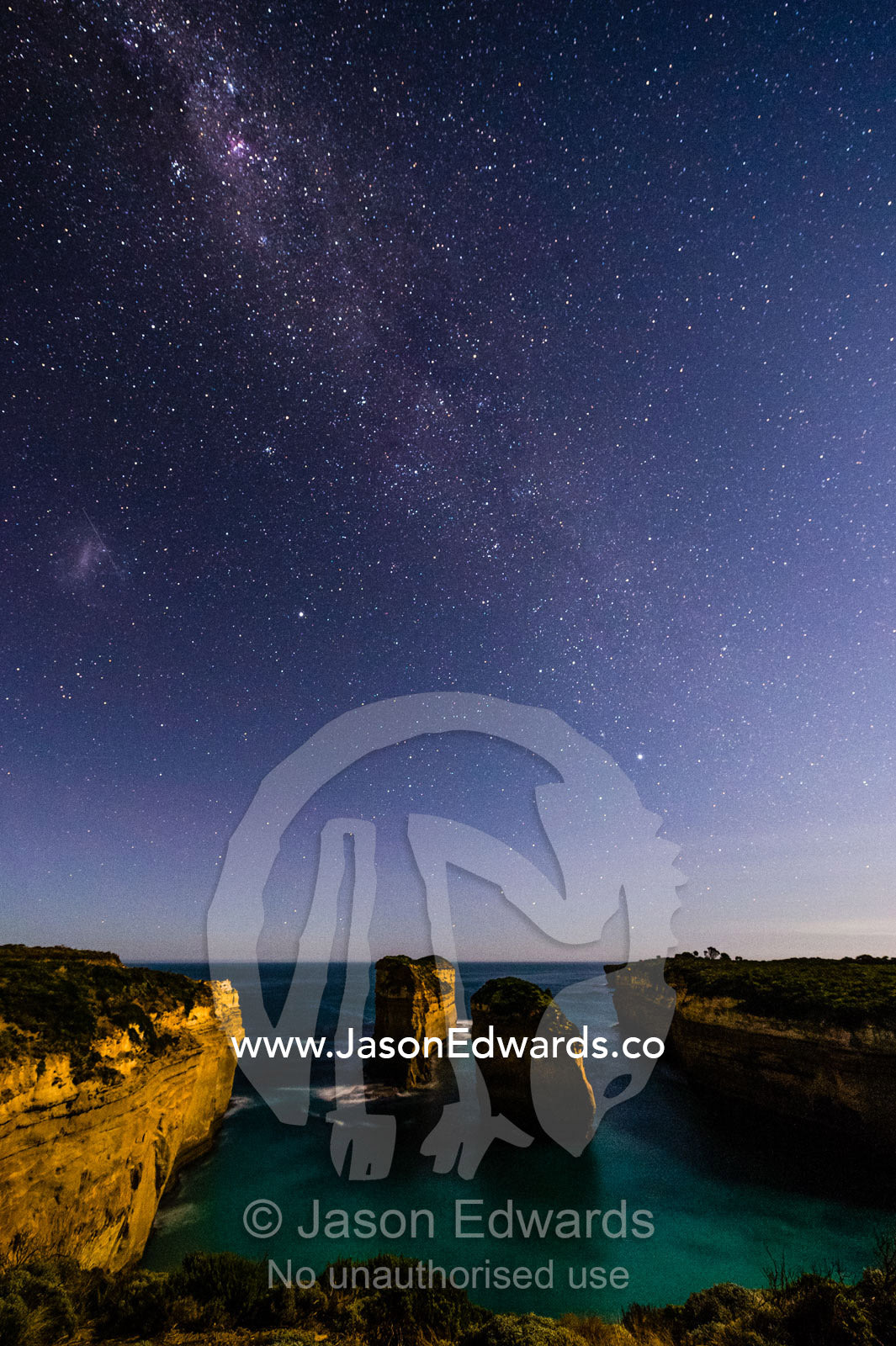 The Milky Way stretches over the ocean and Twelve Apostles, a collection of limestone stacks. Twelve Apostles, Port Campbell National Park, Great Ocean Road, Victoria, Australia.