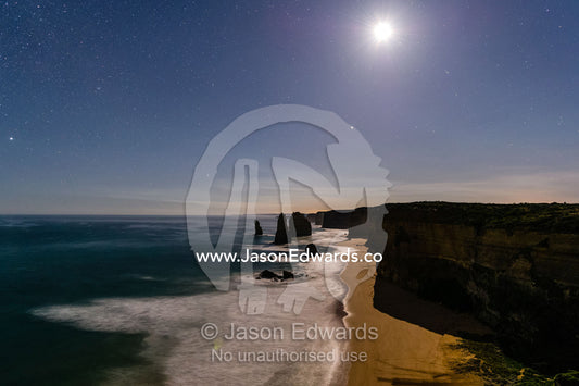 Moonrise over the ocean and Twelve Apostles, a collection of limestone stacks. Twelve Apostles, Port Campbell National, Great Ocean Road, Victoria, Australia.
