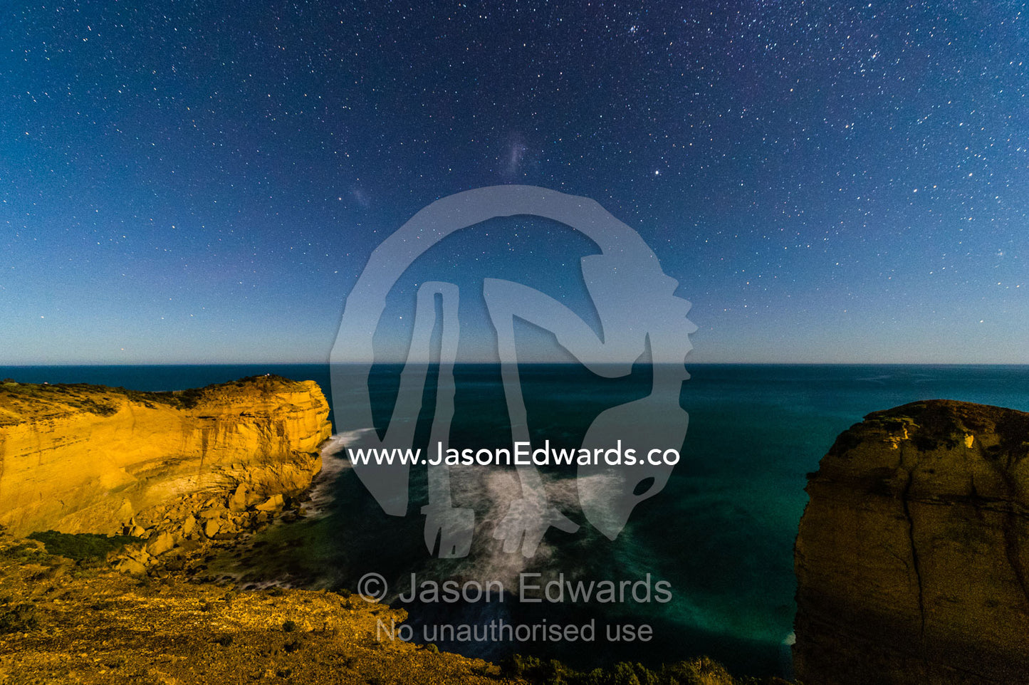 The Milky Way stretches over the ocean and Twelve Apostles, a collection of limestone stacks. Twelve Apostles, Port Campbell National, Great Ocean Road, Victoria, Australia.