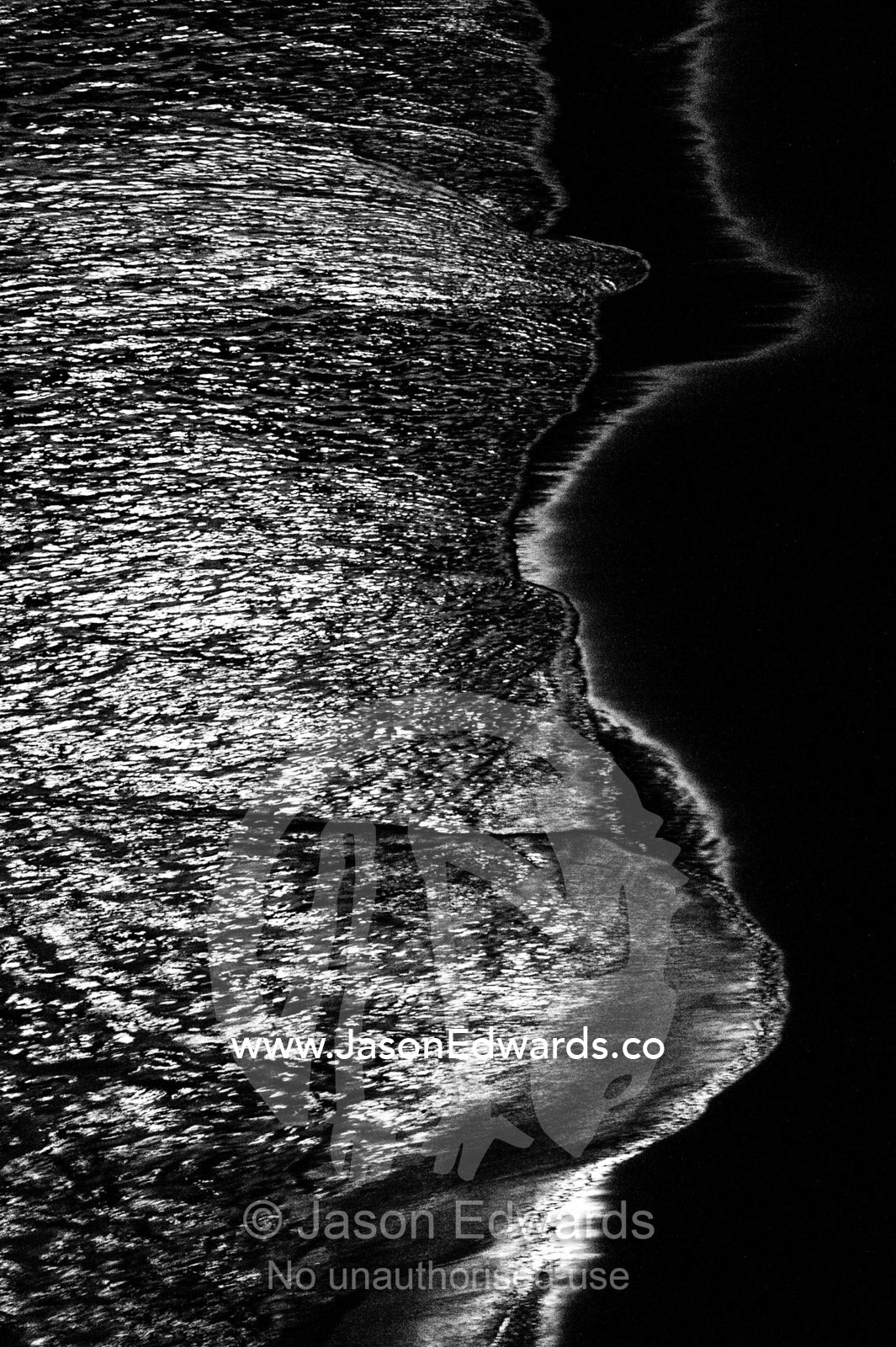 Silvery moonlight reflected in the waves lapping on the shore beneath the Twelve Apostles. Twelve Apostles, Port Campbell National, Great Ocean Road, Victoria, Australia.