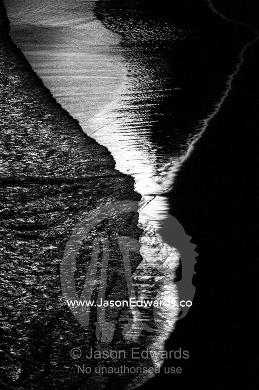 Silvery moonlight reflected in the waves lapping on the shore beneath the Twelve Apostles. Twelve Apostles, Port Campbell National, Great Ocean Road, Victoria, Australia.