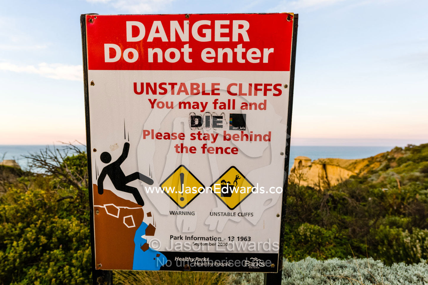 A sign warns hikers to stay away from the sheer limestone cliff. Twelve Apostles, Port Campbell National, Great Ocean Road, Victoria, Australia.